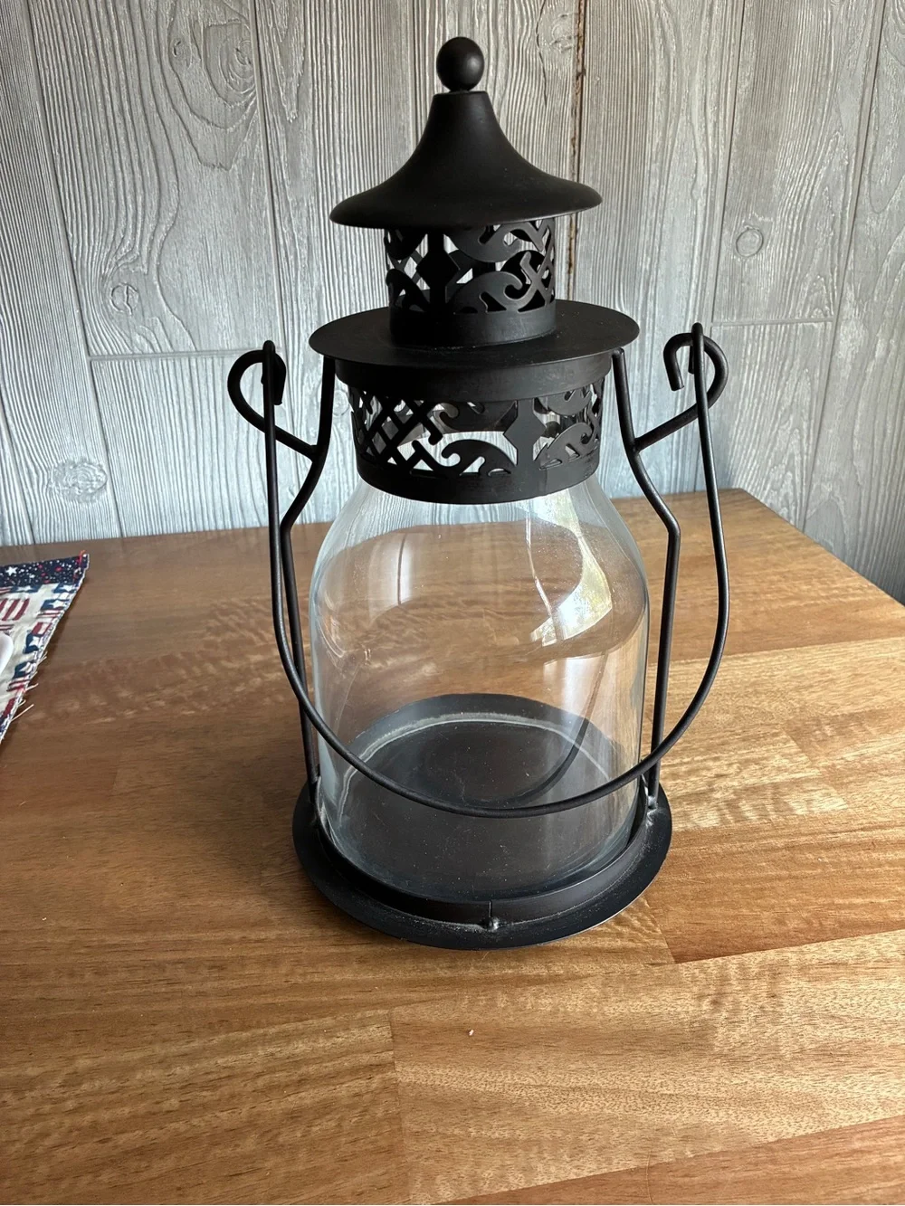 Decorative black metal hurricane lantern/candle lantern. It has a clear glass